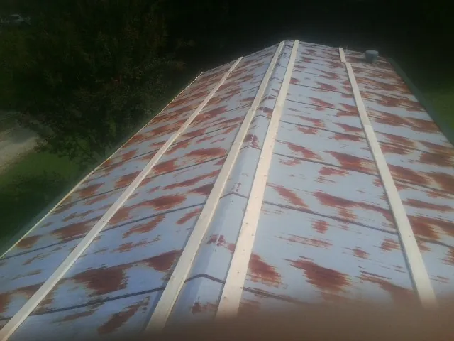 Rusted metal roof panels with new wood purlins before replacement — Storm Damage Roof Repair in Wake by Roofing Brothers